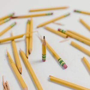 A creatively arranged set of broken and whole yellow pencils on a white background, emphasizing selective focus.